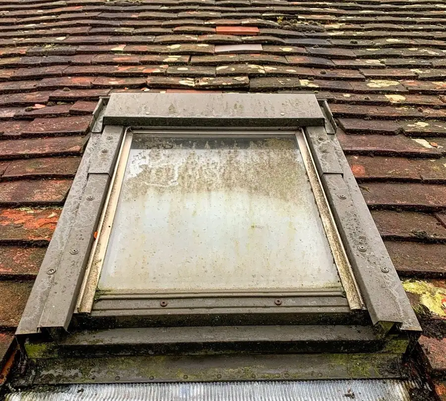 Roof window covered in grime before cleaning