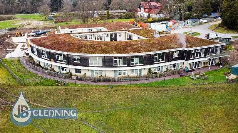 Aerial view of a large curved residential building cleaned by JB Cleaning