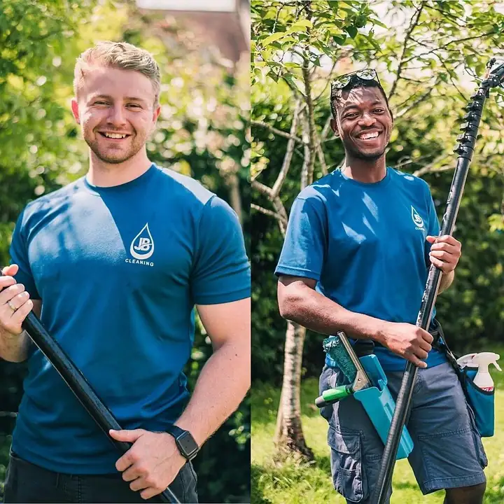 Two members of the JB Cleaning team in uniform holding their poles